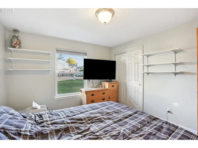 a bedroom with a bed and flat screen tv