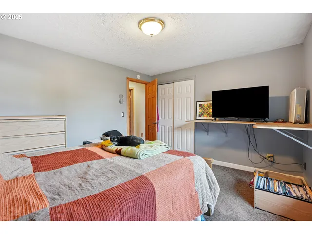 a bedroom with a bed and a flat screen tv