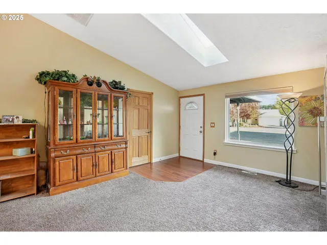 a view of an empty room with furniture and a window