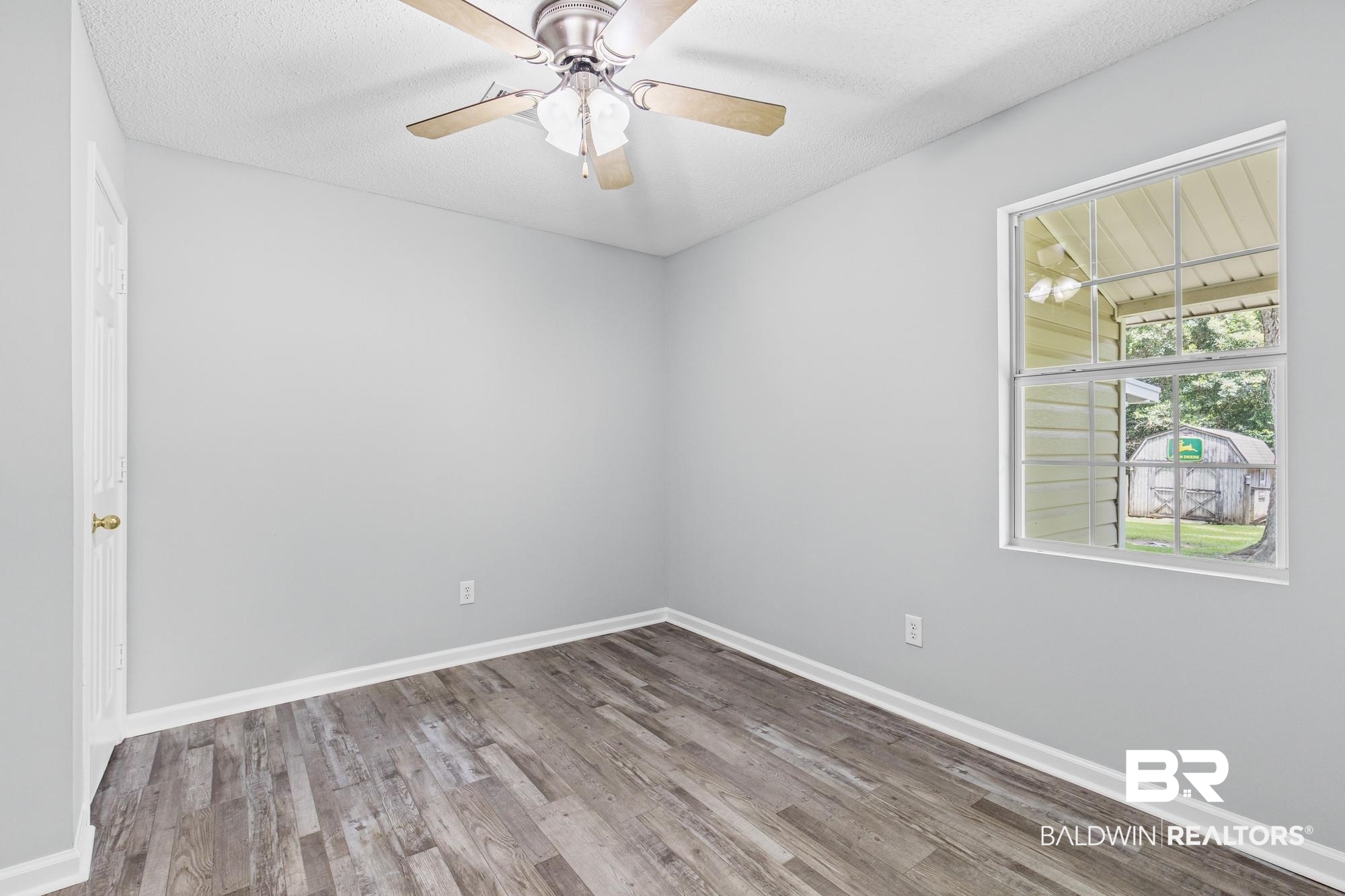 6933 Burbank Court Mobile, AL 36619 - Photo 16 of 25 Room featuring wood-finish flooring, a ceiling fan with light fixture, and a window with white trim