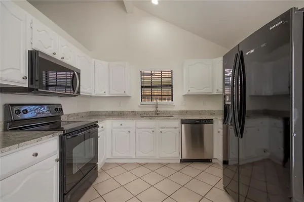 a kitchen with stainless steel appliances granite countertop a refrigerator sink and stove