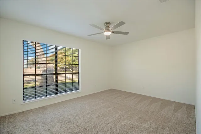 an empty room with chandelier fan