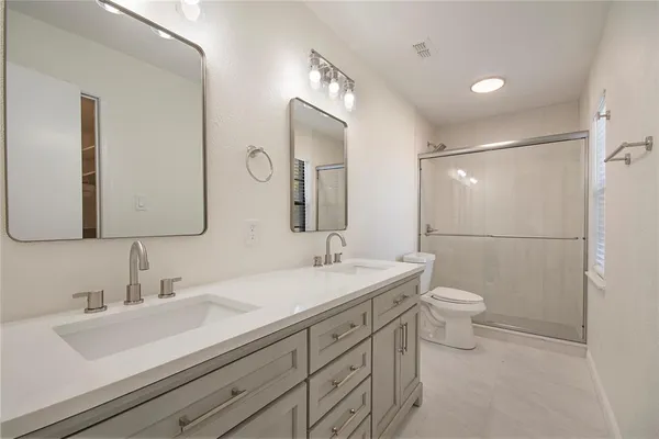 a bathroom with a sink a toilet and a mirror