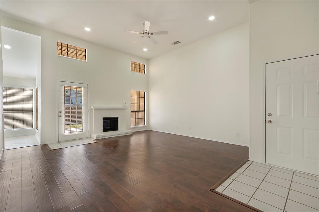 6817 Anderson Drive The Colony, TX 75056 - Photo 2 of 21 an empty room with wooden floor and fireplace