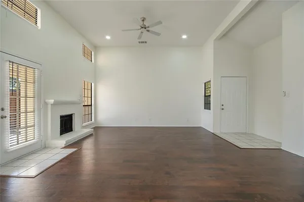 an empty room with windows and fireplace