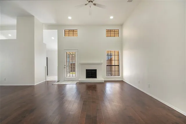 an empty room with wooden floor and fireplace