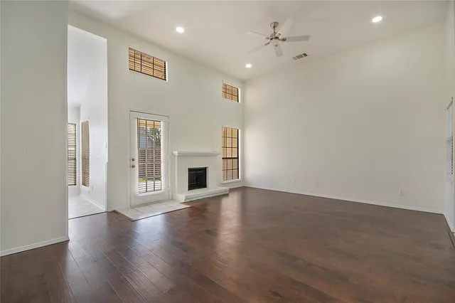 a view of empty room with wooden floor and fireplace