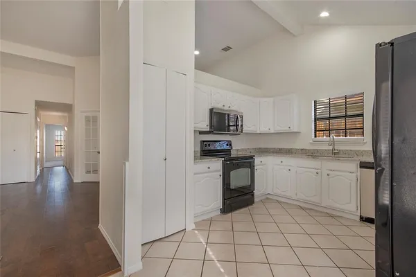 a kitchen with a sink and white cabinets