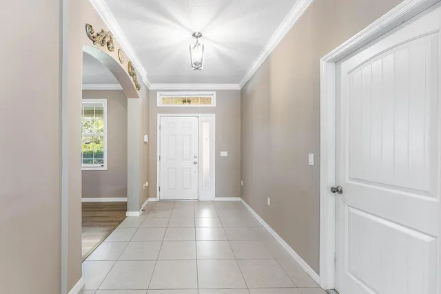 a view of a hallway with a chandelier fan and windows