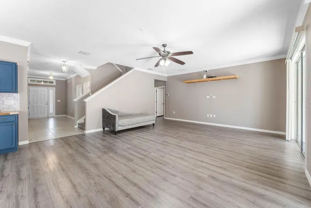 a view of a livingroom with wooden floor and a ceiling fan