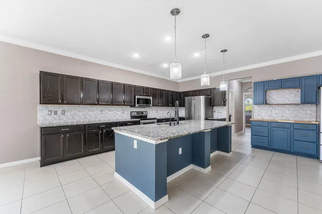 a large kitchen with stainless steel appliances granite countertop a stove and cabinets