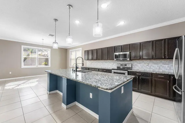 a kitchen with stainless steel appliances granite countertop a sink stove and cabinets