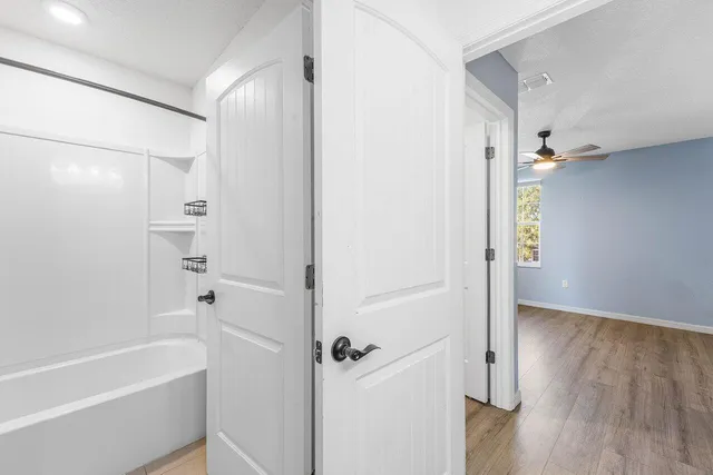 an empty room with a window and a fan