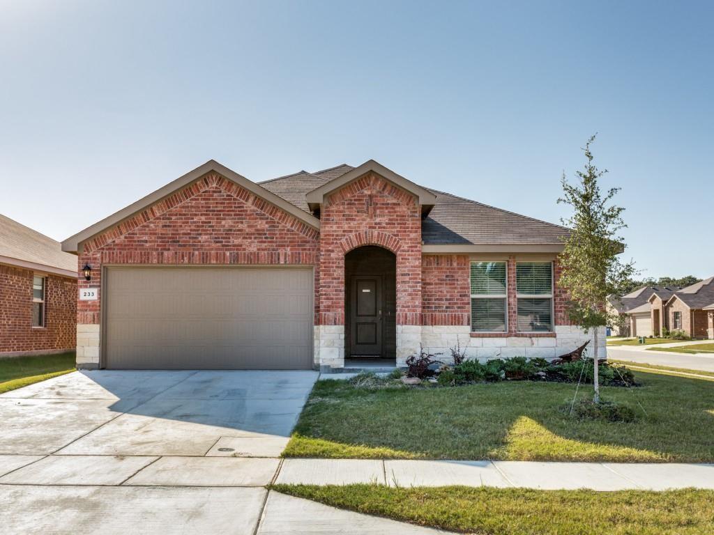 View of front of property featuring brick siding, a garage, driveway, a front yard, and stone siding