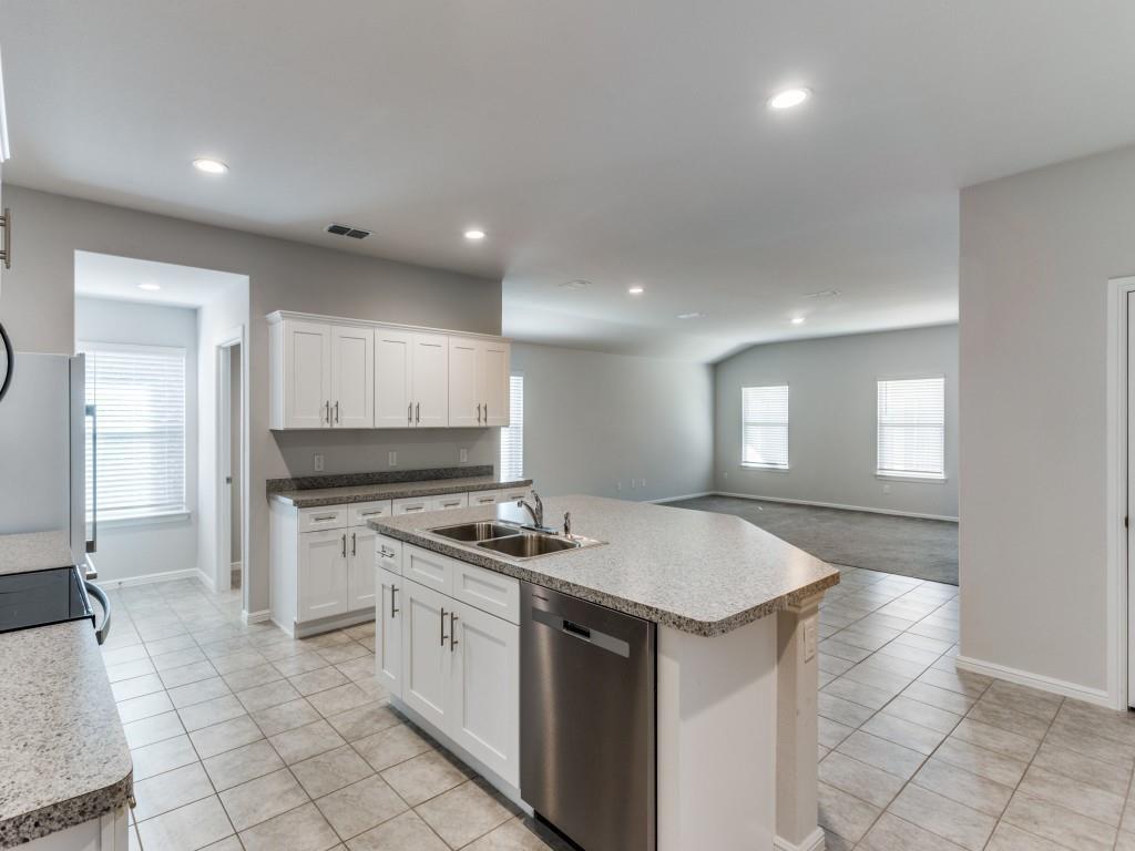233 Abingdon Street Azle, TX 76020 - Photo 3 of 12 Kitchen featuring light tile patterned flooring, dishwasher, an island with sink, white cabinetry, and light countertops