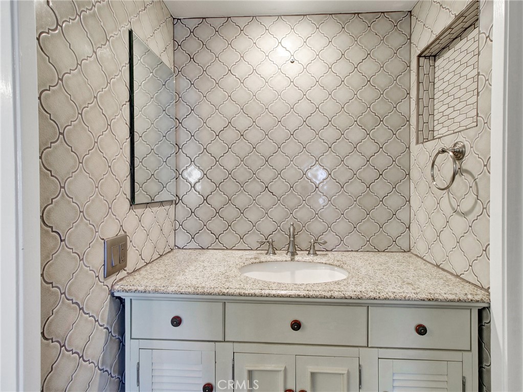 9051 Cobblestone Lane, Unit 40 Cypress, CA 90630 - Photo 32 of 38 a bathroom with a granite countertop sink and a mirror