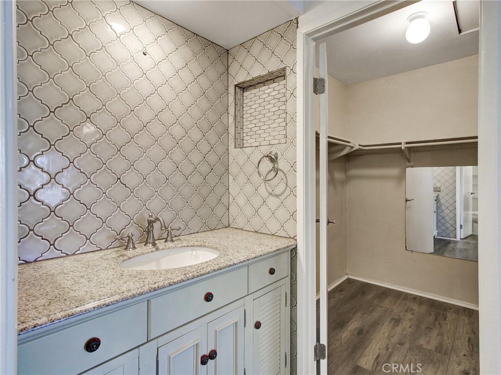 9051 Cobblestone Lane, Unit 40 Cypress, CA 90630 - Photo 33 of 38 a bathroom with a granite countertop sink and a shower