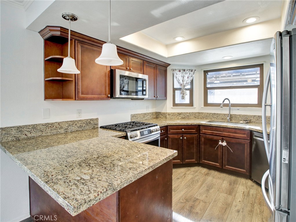 9051 Cobblestone Lane, Unit 40 Cypress, CA 90630 - Photo 5 of 38 a kitchen with stainless steel appliances granite countertop a sink stove and refrigerator