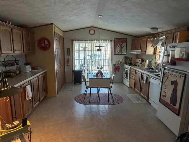 a kitchen with stainless steel appliances granite countertop a stove a sink dishwasher and a refrigerator