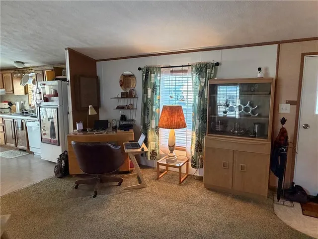 a view of a workspace with furniture and a window