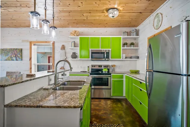 a kitchen with kitchen island granite countertop a sink stainless steel appliances and cabinets