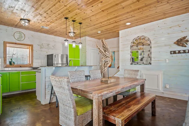 a view of a dining room with furniture a chandelier and a rug