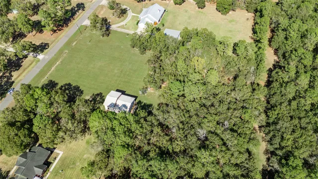 an aerial view of a residential houses with yard