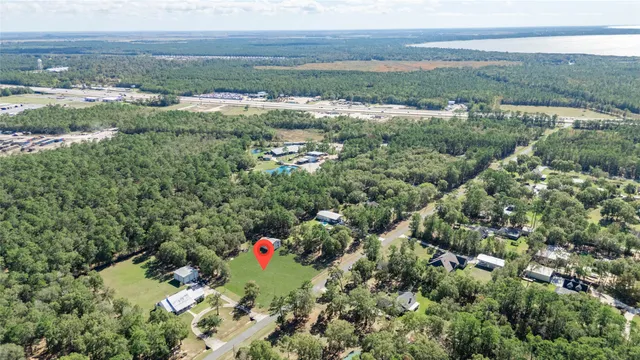an aerial view of residential house with outdoor space and trees