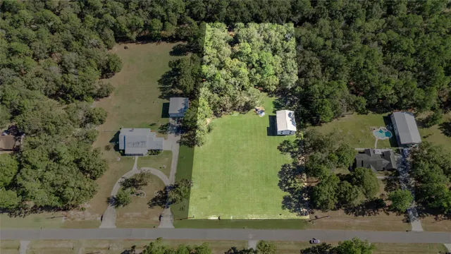 an aerial view of a house with a yard and lake view