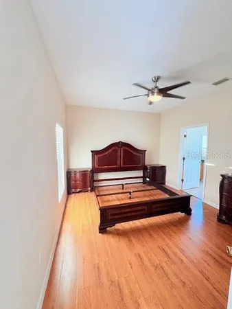a spacious bedroom with a bed and a chandelier