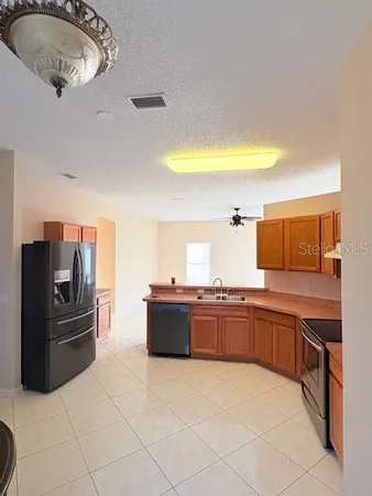 a large kitchen with a stove a refrigerator and a sink
