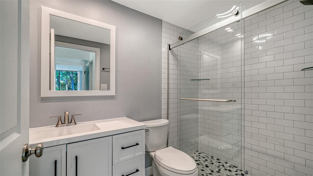 117 Pass Key Road, Unit 117 Sarasota, FL 34242 - Photo 13 of 59 a bathroom with a sink toilet a mirror and shower