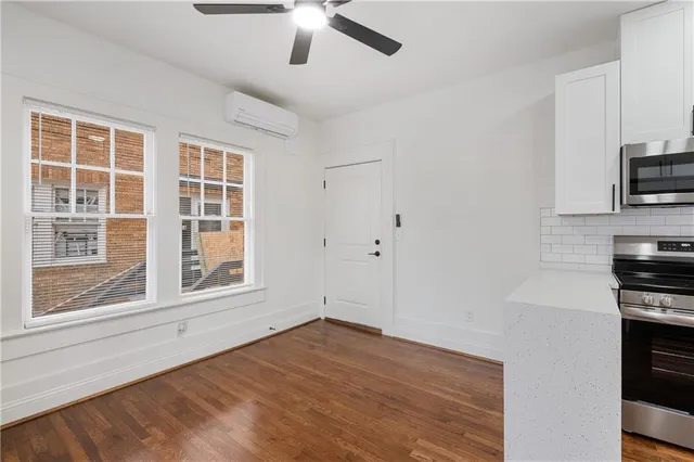 a view of empty room with a ceiling fan and wooden floor