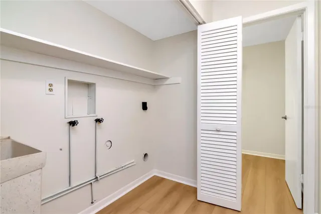 a view of a hallway with wooden floor and cabinet