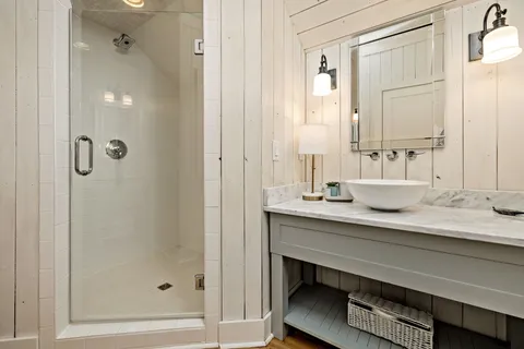 a bathroom with a granite countertop sink a mirror and a shower