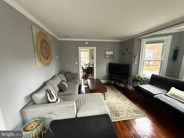 a living room with furniture a flat screen tv and a large window