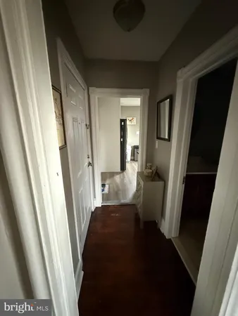 a view of a hallway with a livingroom and furniture