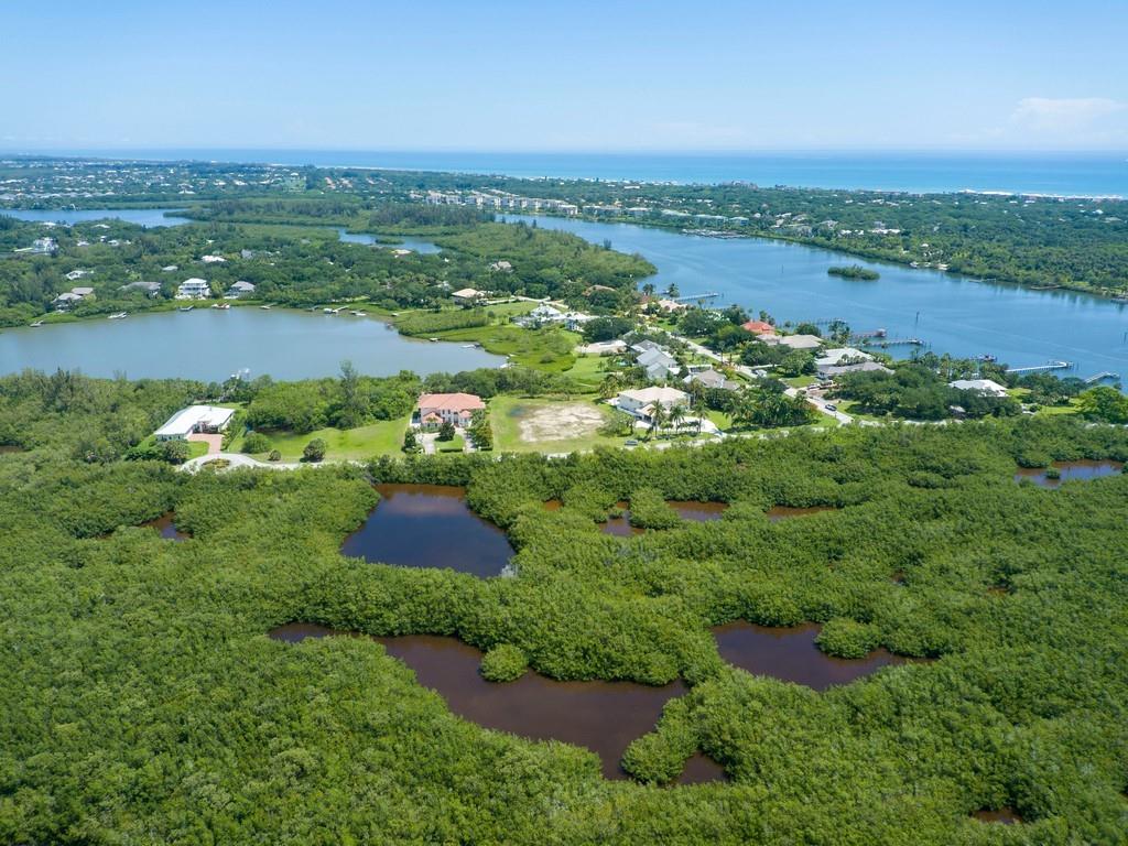 1850 Bayview Court Vero Beach, FL 32963 - Photo 19 of 23 an aerial view of green landscape with trees houses and lake view