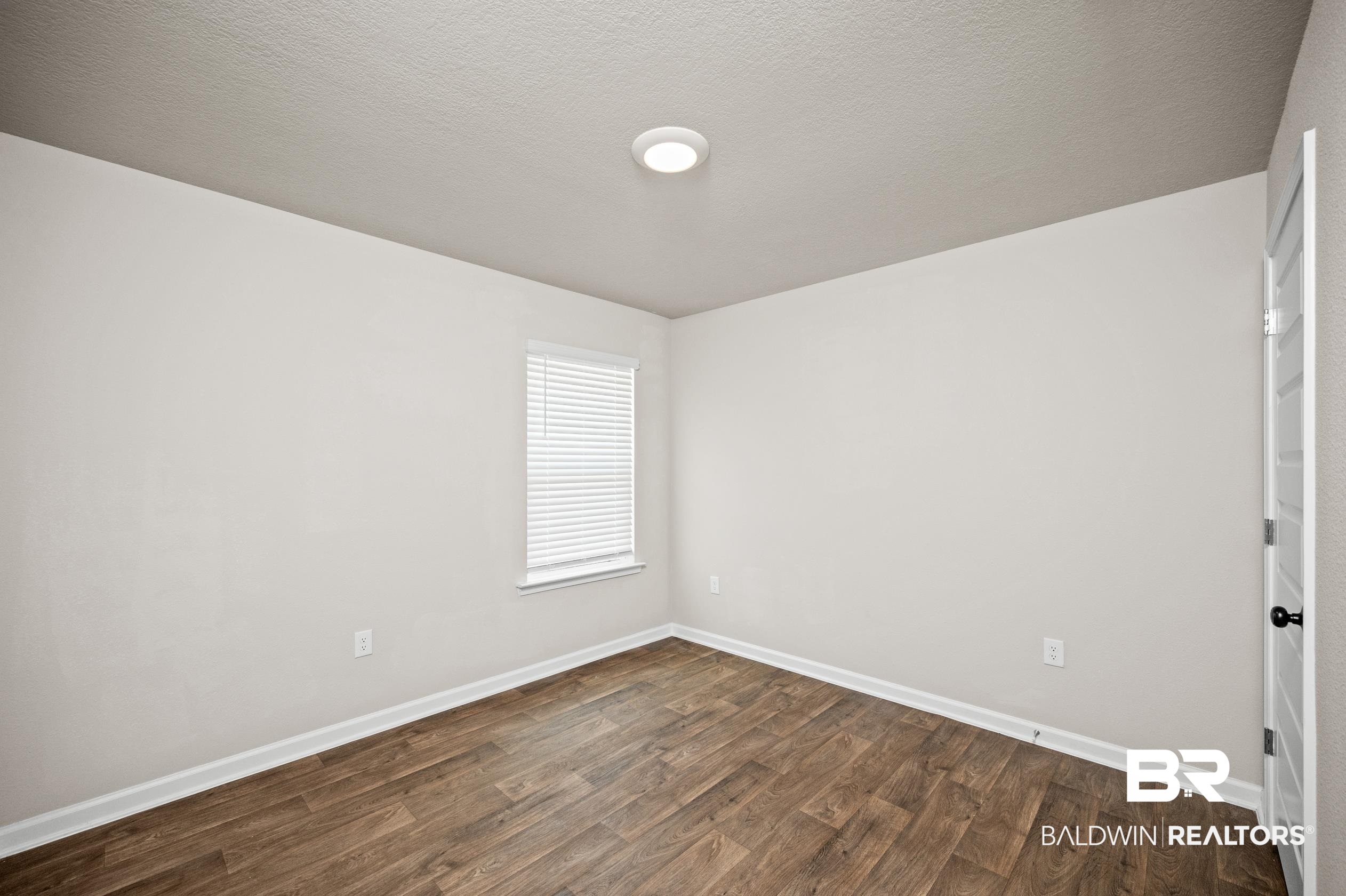 10353 Zenyatta Loop Daphne, AL 36526 - Photo 21 of 33 Spare room with hardwood / wood-style floors and a textured ceiling