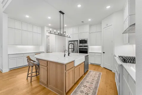 a kitchen with a sink a counter top space stainless steel appliances and cabinets