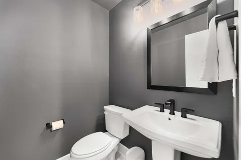 a bathroom with a toilet a sink and mirror