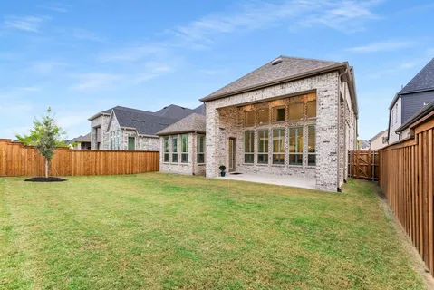 a view of a house with a yard and a large tree