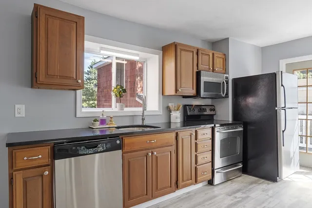 a kitchen with stainless steel appliances a sink cabinets and a window