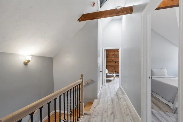 a view of a hallway with wooden floor and staircase