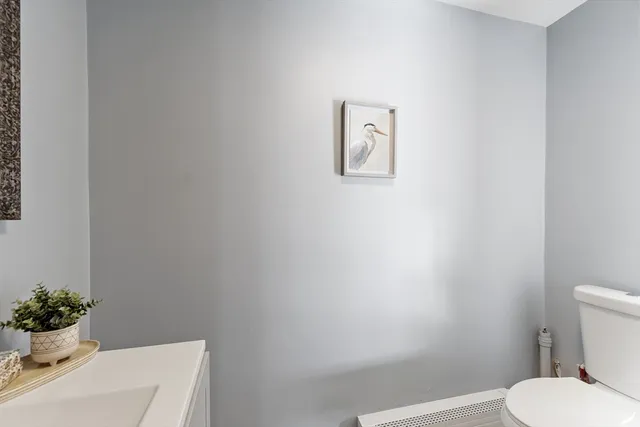 a white toilet sitting next to a white sink and vanity