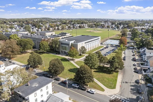 an aerial view of residential houses with outdoor space and lake view