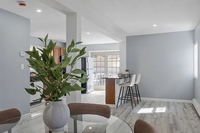 a dining room with furniture a potted plant and wooden floor