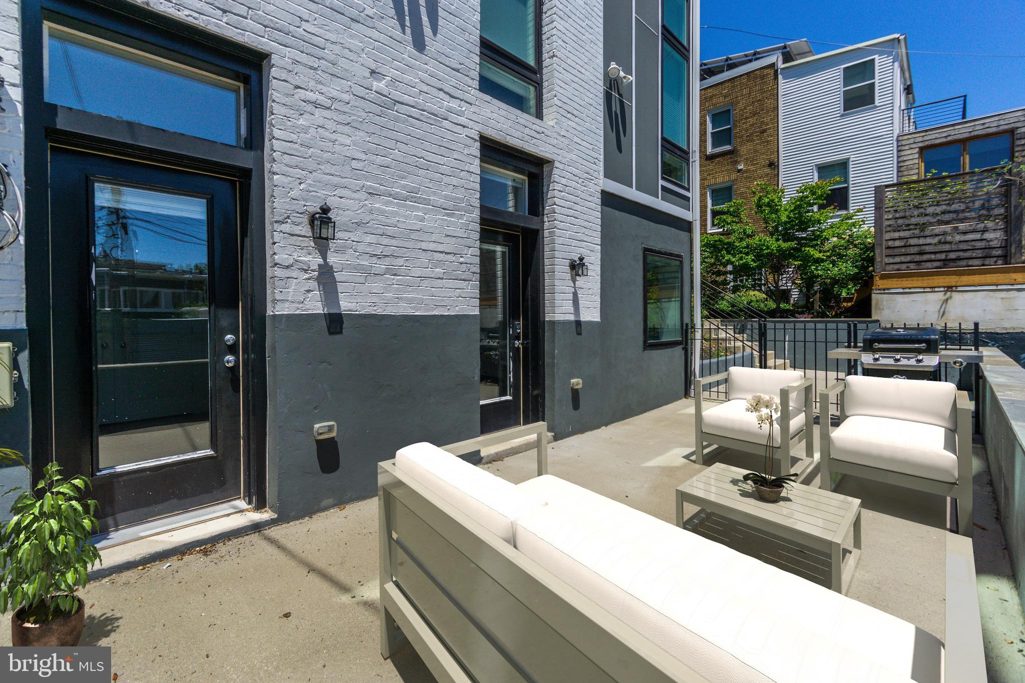 1352 Quincy Street Northwest, Unit 1 Washington, DC 20011 - Photo 2 of 26 a view of a patio with couches table and chairs potted plants