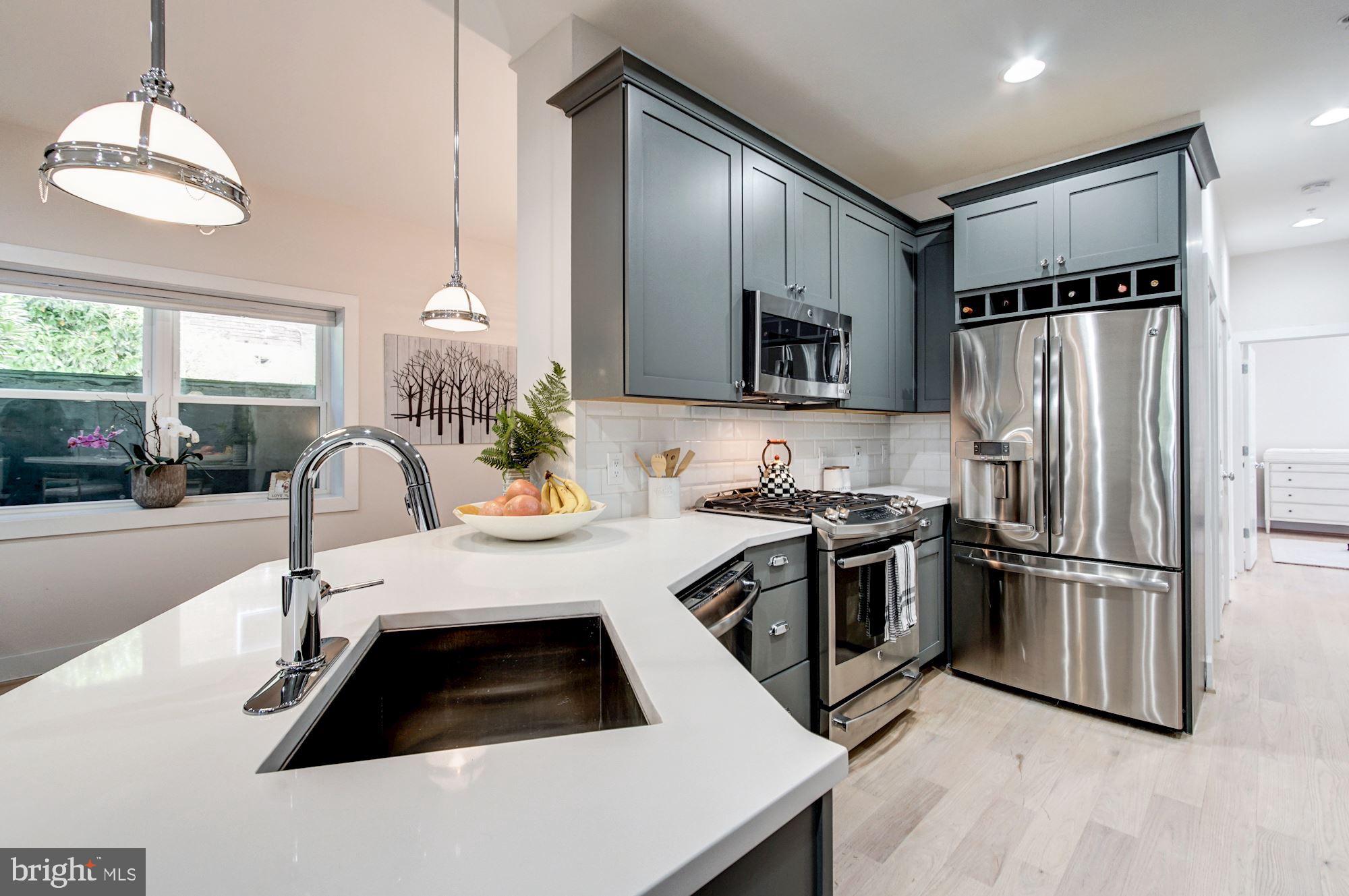 1352 Quincy Street Northwest, Unit 1 Washington, DC 20011 - Photo 5 of 26 a kitchen with stainless steel appliances a sink a stove a refrigerator and cabinets