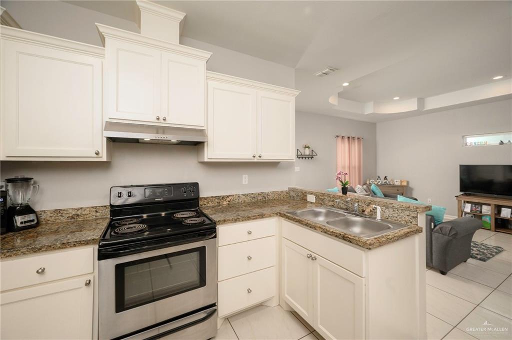473 Pera Avenue Brownsville, TX 78521 - Photo 6 of 17 a kitchen with stainless steel appliances granite countertop a sink stove and cabinets